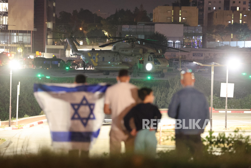 Warga menyaksikan helikopter tentara Israel yang membawa warga Israel yang disandera Hamas di helipad Schneider-Childrens Medical Center di Petah Tikva, Israel, Jumat (24/11/2023). 