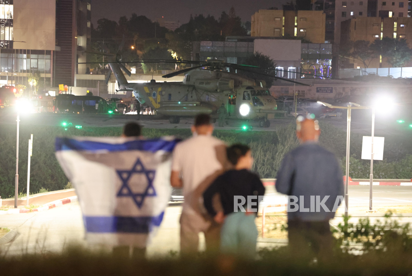 Warga menyaksikan helikopter tentara Israel yang membawa warga Israel yang disandera Hamas di helipad Schneider-Childrens Medical Center di Petah Tikva, Israel, Jumat (24/11/2023).