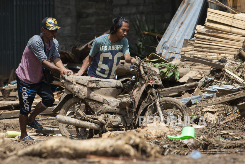 Sejumlah warga mendorong sepeda motornya yang tertimbun lumpur akibat banjir bandang di Adonara Timur, Kabupaten Flores Timur, Nusa Tenggara Timur (NTT), (ilustrasi).