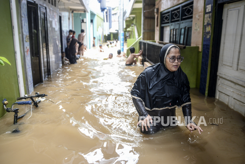 Warga melintasi banjir yang merendam kawasan Kebon Pala, Kampung Melayu, Jatinegara, Jakarta Timur, Senin (8/11/2021). Intensitas hujan yang tinggi serta meluapnya sungai Ciliwung membuat sejumlah wilayah di Ibu Kota terendam banjir. 