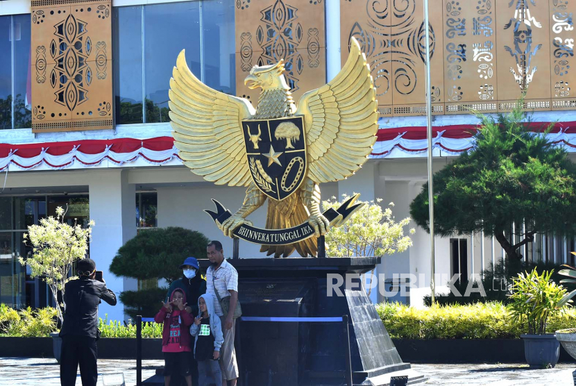 Sejumlah warga berfoto didepan lambang negara Garuda Pancasila di Pos Lintas Batas Negara (PLBN) Skouw, Distrik Muara Tami, Kota Jayapura, Papua, Selasa (23/8/2022). 