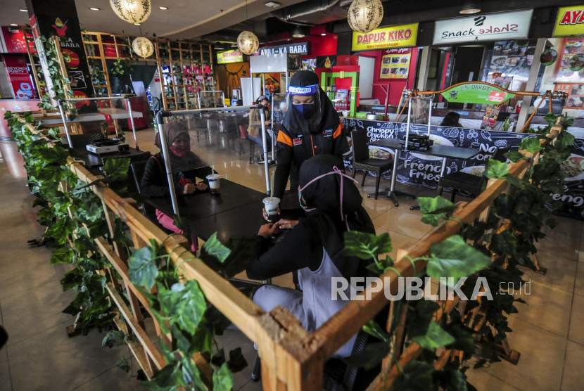 Meja restoran di Bekasi, Jawa Barat, dipasangi pembatas plastik untuk menjaga pengunjung agar tak terkena paparan droplet saat melepas masker ketika makan. 