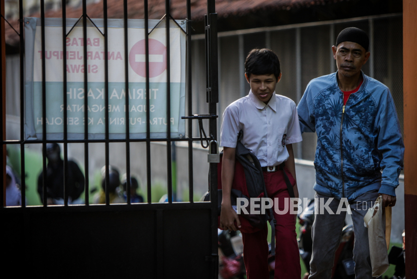 Orang tua siswa mengantarkan anaknya saat hari pertama sekolah di SLB Negeri Sejahtera, Kota Bogor, Jawa Barat, Senin (17/7/2023). Sebanyak 18 siswa yang terdiri dari tuna netra, tuna rungu, tuna grahita dan tuna daksa di SLB tersebut mengikuti kegiatan Masa Pengenalan Lingkungan Sekolah (MPLS) pada tahun ajaran 2023/2024.