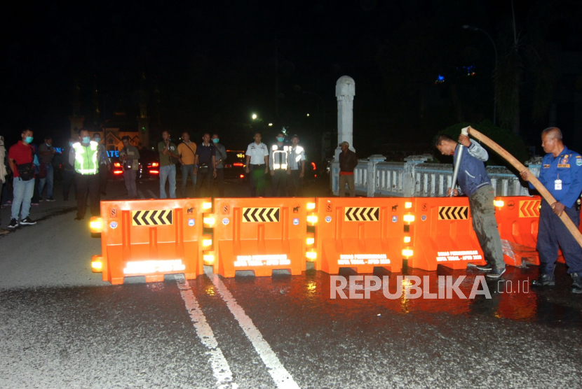 Petugas melakukan pengalihan jalur saat penutupan sebagian jalan protokol Kota Tegal, Jawa Tengah, Senin (22/3/2020) 