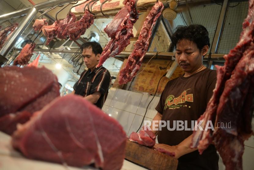 Harga Masih Tinggi. Pedagang daging sapi melayani pembali di pasar tradisional, Jakarta, Ahad (24/6).