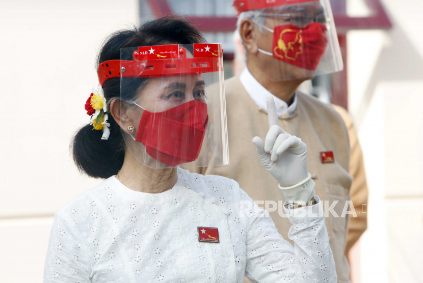  Pemimpin Myanmar Aung San Suu Kyi memberi isyarat saat mengenakan pelindung wajah, masker dan sarung tangan selama upacara pengibaran bendera untuk menandai hari pertama kampanye pemilihan umum di markas sementara partai Liga Nasional untuk Demokrasi di Naypyitaw, Myanmar pada Selasa, 8 September, 2020. Myanmar mengadakan pemilihan umum pada 8 November dan memulai periode kampanye enam puluh hari pada Selasa, yang mungkin terganggu karena kebangkitan virus corona.