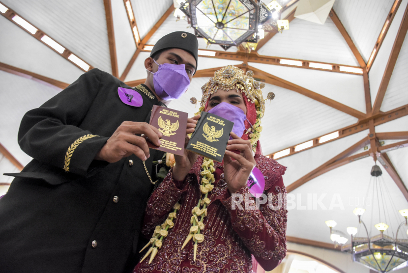 Pasangan pengantin difabel menunjukkan buku nikah usai prosesi akad pada kegiatan Nikah Massal Difabel di Masjid Pusdai, Kota Bandung, Kamis (2/12). PBNU: Pernikahan Perlu Dibangun di atas Kesamaan Akidah 