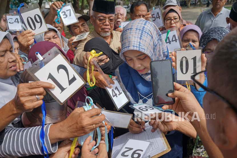 Officers serve elderly (elderly) pilgrims from Banda Aceh.