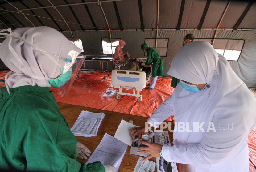 Petugas medis melakukan screening pasien ditenda darurat di depan IGD RSU Cut Meutia Aceh Utara, Aceh, Selasa (22/9/2020). Screening bagi pasien yang berobat ke rumah sakit tersebut dilakukan untuk penyaringan pasien sebelum masuk IGD, mengantisipasi penularan COVID-19 dari pasien kepada para tenaga Kesehatan, menyusul semakin meningkatnya kasus COVID-19 di Aceh. 