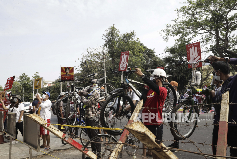  Para pengunjuk rasa membawa sepeda mereka selama protes menentang kudeta militer di luar Kedutaan Besar China di Yangon, Myanmar, 19 Februari 2021. acebook menghapus halaman utama militer Myanmar pada Ahad (21/2/2021). 