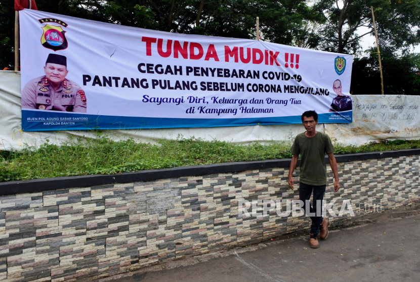 Warga melintas di dekat spanduk seruan untuk menunda mudik menjelang puasa dan lebaran di Jalan Sudirman, Serang, Banten, Kamis (9/4/2020). Pemda setempat bersama tokoh masyarakat menempuh berbagai langkah untuk memutus rantai penyebaran COVID-19 termasuk menyebar spanduk berisi seruan untuk menunda mudik