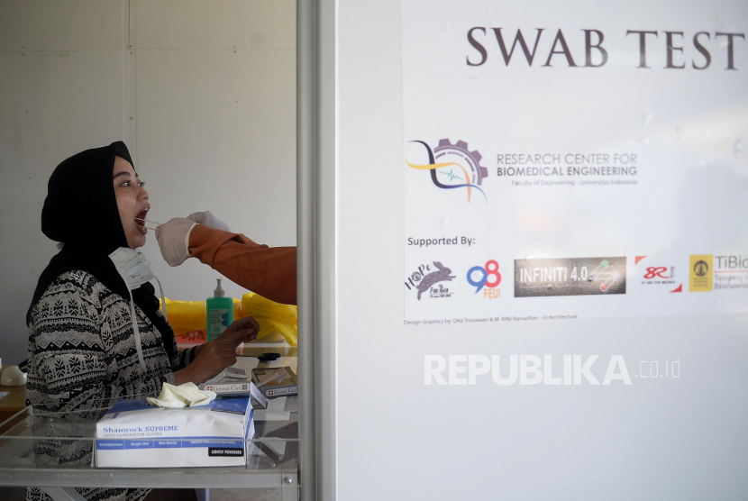 Tenaga medis mengambil sampel lendir pasien dari bilik swab test chamber saat tes swab massal di Rumah Sakit Universitas Indonesia (RSUI), Depok, Jawa Barat, Selasa (2/6).