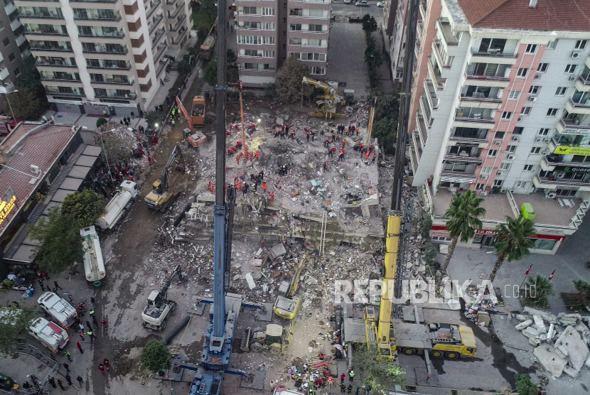 Sebuah foto yang dibuat dengan drone menunjukkan petugas penyelamat dan orang-orang yang mencari korban di sebuah bangunan yang runtuh setelah gempa berkekuatan 7,0 yang berasal dari Laut Aegean, melanda daerah di Izmir, Turki, Ahad (1/11/2020).. Menurut laporan media, setidaknya 49 orang telah meninggal dan lebih dari 800 orang terluka selama gempa bumi.