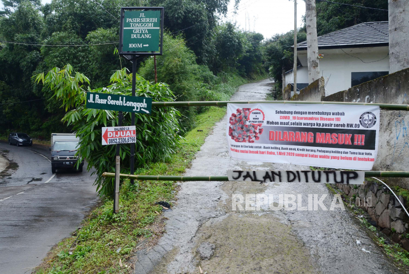 Blokade bambu bergambar virus Corona dipasang di jalan masuk Jalan Pasir Sereh Tonggoh, Kecamatan Parongpong, Kabupaten Bandung Barat, Senin (6/4). Penutupan jalan tersebut dilakukan untuk mencegah orang dari luar kampung masuk, sebagai upaya mencegah penularan wabah Covid-19