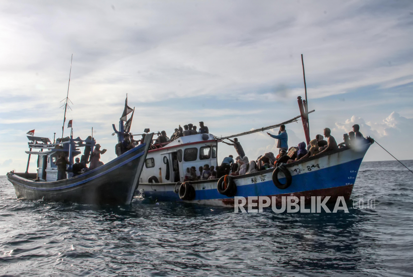 Kapal nelayan (kiri) mengikat kapal yang ditumpangi pengungsi etnis Rohingya untuk ditarik dari tengah laut menuju pesisir Bayu, Aceh Utara, Aceh, Rabu (24/6/2020). Sebanyak 94 orang pengungsi etnis Rohingya, terdiri dari 15 orang laki-laki, 49 orang perempuan dan 30 orang anak-anak ditemukan terdampar di tengah laut dengan kondisi kapal rusak, sementara sebanyak 15 orang lainnya dilaporkan meninggal di laut selama mereka terdampar di perairan Indonesia hingga ke Aceh. 