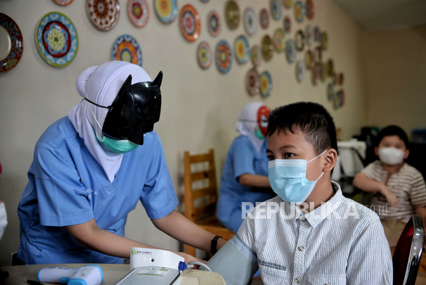 Tenaga kesehatan menggunakan topeng pahlawan super (superhero) saat mengecek tensi darah anak saat melayani vaksinasi anak usia 6-11 tahun di RSIA Tambak, Menteng, Jakarta Pusat, Rabu (22/12/2021). Tekanan darah dapat bervariasi sepanjang hari.