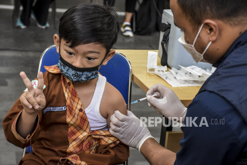 Vaksinator menyuntikkan vaksin Covid-19 ke seorang anak di Lobby Langit 23 Paskal, Kota Bandung, Kamis (28/7/2022). Kementerian Kesehatan berencana memberikan vaksin Covid-19 dosis keempat atau booster kedua yang diprioritaskan untuk empat juta tenaga kesehatan (nakes). Hingga Rabu (27/7/2022), total capaian vaksinasi Covid-19 booster di Indonesia sebanyak 26,54 persen atau 55.275.438 penduduk. Foto: Republika/Abdan Syakura