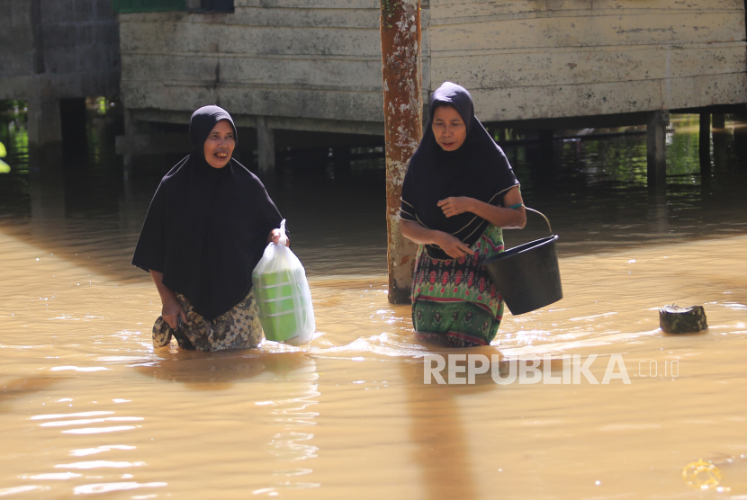 Sejumlah warga melintasi genangan banjir di depan rumahnya yang terendam banjir. Banjir melanda desa-desa di 12 kecamatan di wilayah Kabupaten Aceh Utara. Ilustrasi.