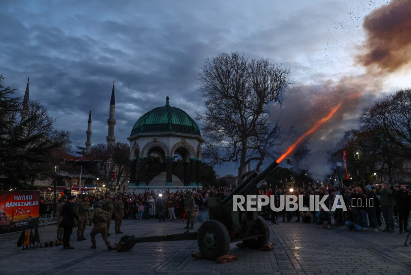 Tentara menembakkan meriam untuk menandai berakhirnya puasa dan saatnya berbuka puasa di hari pertama Ramadhan di depan Masjid Sultanahmet (Biru) di Istanbul, Turki, (23/3/2023). 