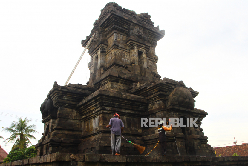 Anggota tim pemeliharaan dari Balai Pelestarian Cagar Budaya (BPCB) Trowulan membersihkan lumut dengan menyemprotkan air bertekanan tinggi di badan Candi Singosari, Malang, Jawa Timur. 