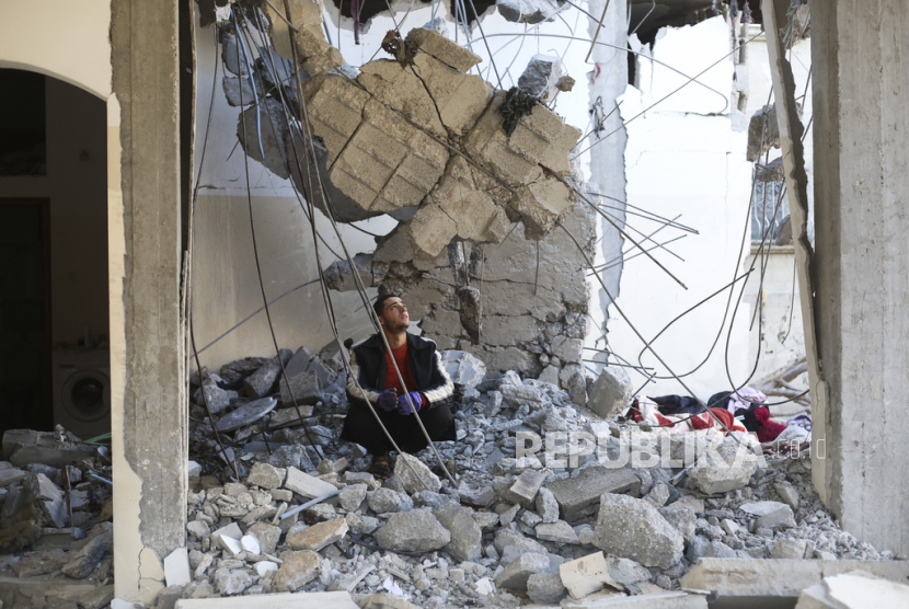 Seorang warga Palestina melihat kehancuran setelah serangan Israel terhadap sebuah bangunan tempat tinggal di Rafah, Jalur Gaza, Rabu, (21/2/2024).