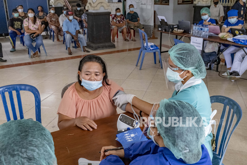 Seorang perempuan menjalani pemeriksaan kesehatan sebelum menerima suntikan vaksin COVID-19 saat kampanye vaksinasi COVID-19 massal untuk lansia di Denpasar, Bali, Indonesia, 06 April 2021. 