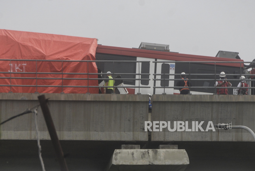 Petugas mengecek kereta LRT yang mengalami kecelakaan di kawasan Cibubur, Jakarta, Senin (25/10). Dua kereta LRT Jabodebek yang masih dalam tahap uji coba mengalami kecelakaan di jalur layang ruas Cibubur-TMII pada pukul 12.30 WIB hingga kini masih dalam tahap pemeriksaan. Republika/Putra M. Akbar