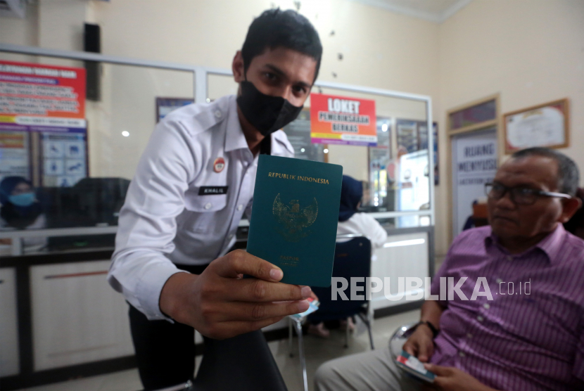 Petugas kantor Imigrasi Banda Aceh memperlihatkan paspor milik warga yang akan diperpanjang masa berlaku di Banda Aceh; Aceh; Rabu (12/10/2022). 