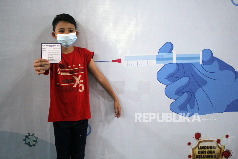 Seorang anak menunjukkan kartu vaksinnya saat vaksinasi COVID-19 khusus anak usia 12-17 tahun, ilustrasi