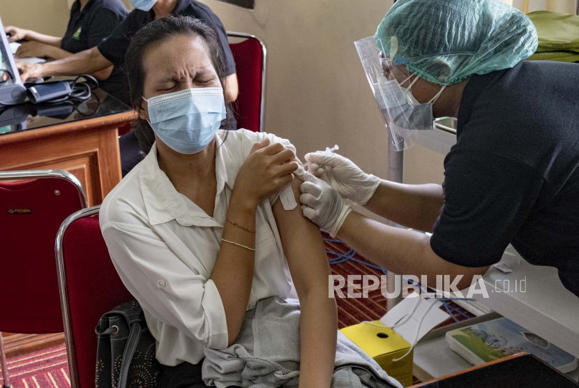 Seorang petugas kesehatan disuntik vaksin COVID-19 di pusat vaksinasi di Denpasar, Bali, Indonesia, 29 Januari 2021. Indonesia telah melaporkan lebih dari satu juta kasus COVID-19 sejak awal pandemi, jumlah tertinggi di Tenggara. Asia.