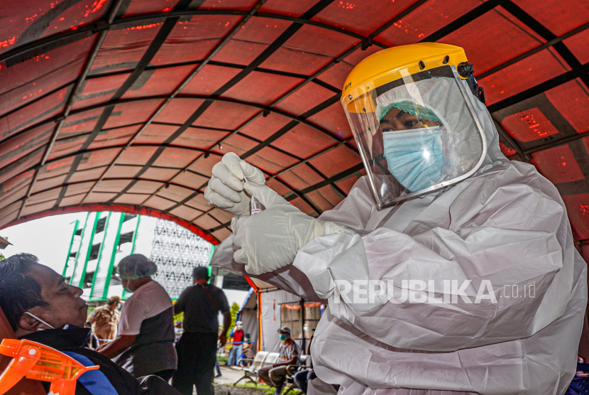 Petugas memasukkan sampel swab atau usap nasofaring ke dalam wadah di Laboratorium Kesehatan Daerah (Labkesda) Dok II Jayapura, Papua, Senin (1/2/2021). 