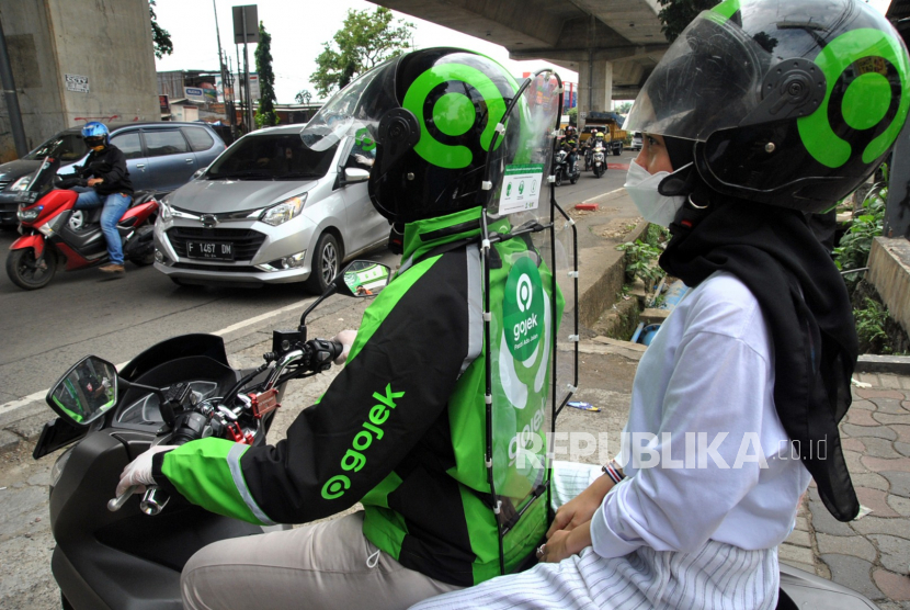 Pengemudi ojek daring menggunakan sekat pembatas saat mengantar penumpang. Polres Metro Jakarta Barat dan Kodim 0503 merangkul komunitas ojek daring untuk bergabung dalam Satuan Tugas Pencegahan COVID-19.