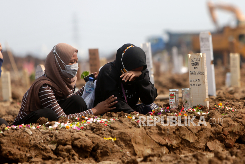Muhammadiyah Minta Umat Lebih Sabar dan Tegar Hadapi Pandemi. Kerabat berduka setelah pemakaman orang tua mereka yang meninggal dengan COVID-19 di pemakaman yang didedikasikan untuk korban COVID-19 di Jakarta, Indonesia, 7 Juli 2021.