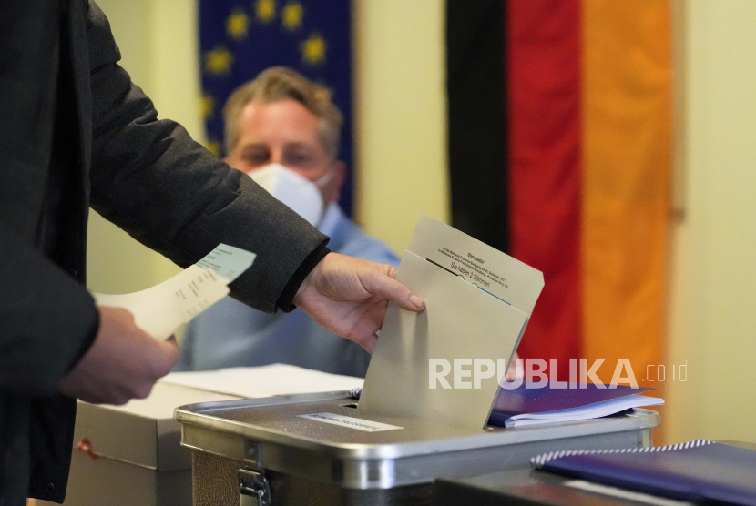 Seorang pria memberikan suaranya untuk pemilihan parlemen nasional Jerman di sebuah tempat pemungutan suara di Berlin, Jerman, Ahad (26/9).