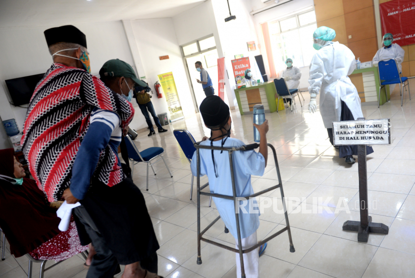 Jamaah calon haji digendong menuju tempat penyuntikan vaksin Covid-19 massal di Halaman Dinas Kesehatan Bantul, Yogyakarta, Selasa (6/4). Sebanyak 400 jamaah calon haji kategori lanjut usia mengikuti vaksinasi Covid-19 massal. Waktu penyuntikan vaksin Covid-19 dilakukan dua hari. Kemenag Bantul Tunggu Kebijakan Pusat Terkait Pelaksanaan Haji