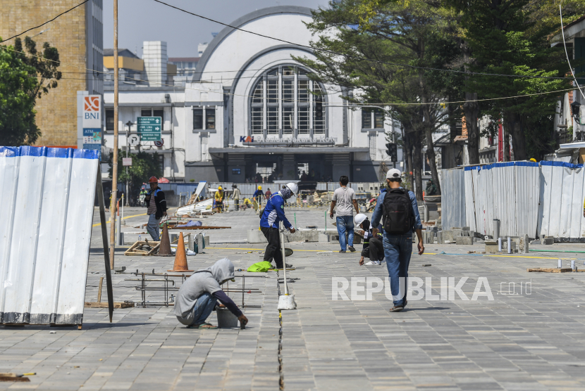 Pekerja menyelesaikan proyek revitalisasi jalur pedestrian di kawasan Kota Tua, Jakarta Barat, Selasa (5/7/2022), yang membuat ratusan PKL harus direlokasi.