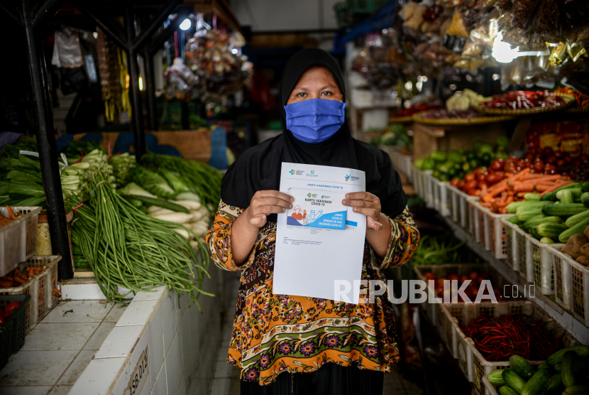 Warga menunjukan kartu vaksin Covid-19 usai menerima vaksin dosisi kedua saat kegiatan layanan vaksin keliling di Pasar Gang Kancil, Jakarta (ilustrasi)