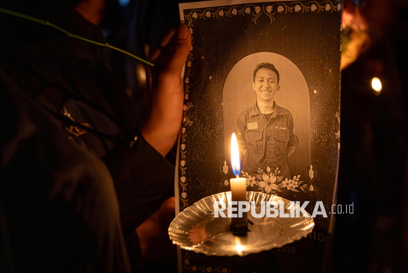 Seorang peserta  menyalakan lilin dan membawa foto Iko saat aksi solidaritas meninggalnya mahasiswa Fakultas Hukum Universitas Negeri Semarang (Unnes) Iko Juliant Junior di Unnes, Semarang, Jawa Tengah, Selasa (2/9/2025). Aksi yang diikuti ratusan mahasiswa dan alumni gabungan sejumlah universitas di Kota Semarang dan sekitarnya itu untuk mendoakan Iko yang dinilai meninggal secara janggal, serta untuk mendoakan peserta aksi unjuk rasa di Indonesia yang mengalami luka-luka maupun meninggal dunia. 