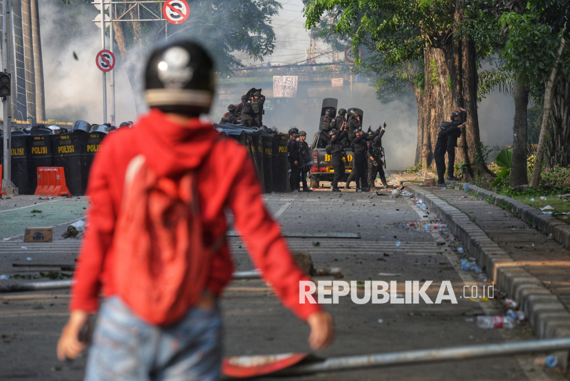 Personel Brimob mencoba membubarkan pengunjuk rasa di depan Markas Komando Brimob Polda Metro Jaya, Kwitang, Jakarta, Jumat (29/8/2025). Aksi tersebut menuntut pengusutan kasus penabrakan pengemudi ojek online oleh mobil rantis Brimob.