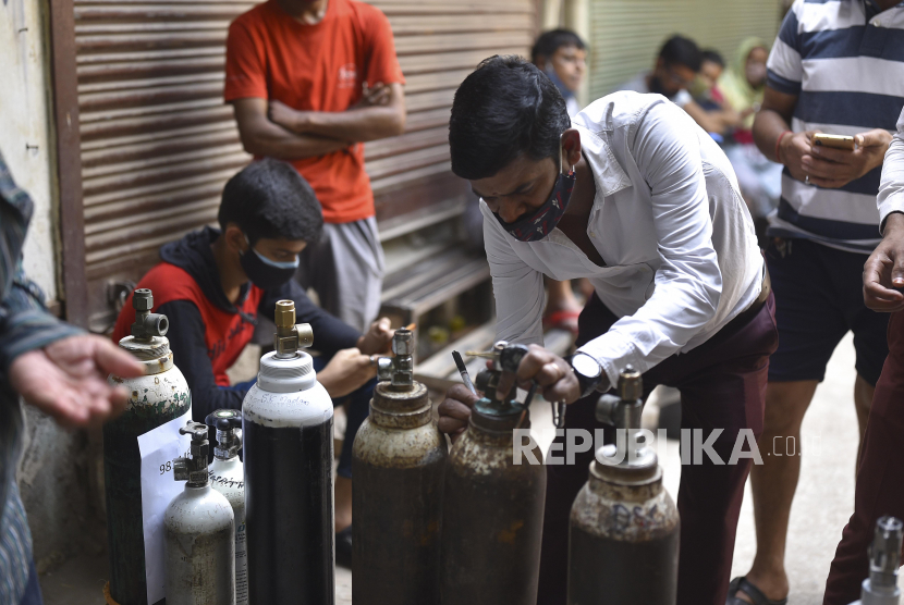 Sejumlah warga menunggu untuk mengisi tabung oksigen di New Delhi, India, Kamis (29/4). Delhi melaporkan 25.986 kasus baru, 368 kematian dalam 24 jam terakhir dan terus berjuang dengan pasokan oksigen yang ada. EPA-EFE/IDREES MOHAMMED