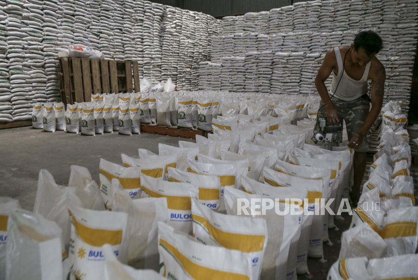 Pekerja mengemas karung beras di gudang Bulog Pasirhalang, Sukaraja, Kabupaten Sukabumi, Jawa Barat, Selasa (5/12/2023).