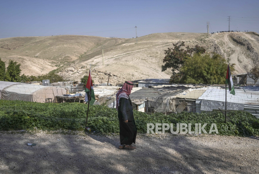 Seorang pria Palestina berjalan di dusun Bedouin Khan al-Ahmar di Tepi Barat, Senin, 23 Januari 2023. Lusinan warga Palestina dan aktivis pada Senin memprotes ancaman baru oleh politisi Israel untuk segera melakukan penggusuran Khan al-Ahmar. Ahmar, yang menurut para kritikus berada di bawah ancaman pembongkaran untuk memberi ruang bagi lebih banyak pemukiman Yahudi.