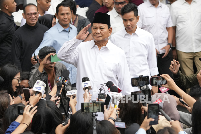 Indonesian Defense Minister and president-elect Prabowo Subianto, center, salutes to journalists in front of his running mate Gibran Rakabuming Raka, rear center, the eldest son of Indonesian President Joko Widodo, during their formal declaration as president and vice president-elect at the General Election Commission building in Jakarta, Indonesia, Wednesday, April 24, 2024. Indonesia