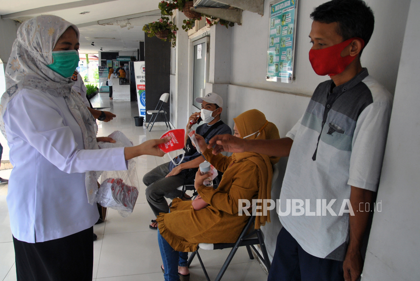 Petugas kesehatan membagikan masker kepada warga (ilustrasi)