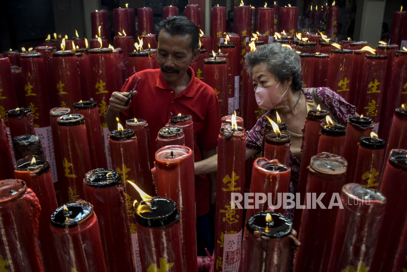 Petugas bantu warga menyalakan lilin di vihara (ilustrasi). olisi mengerahkan 248 personel untuk mengamankan vihara dan klenteng di wilayah Jakarta Timur dalam perayaan Imlek 2024.