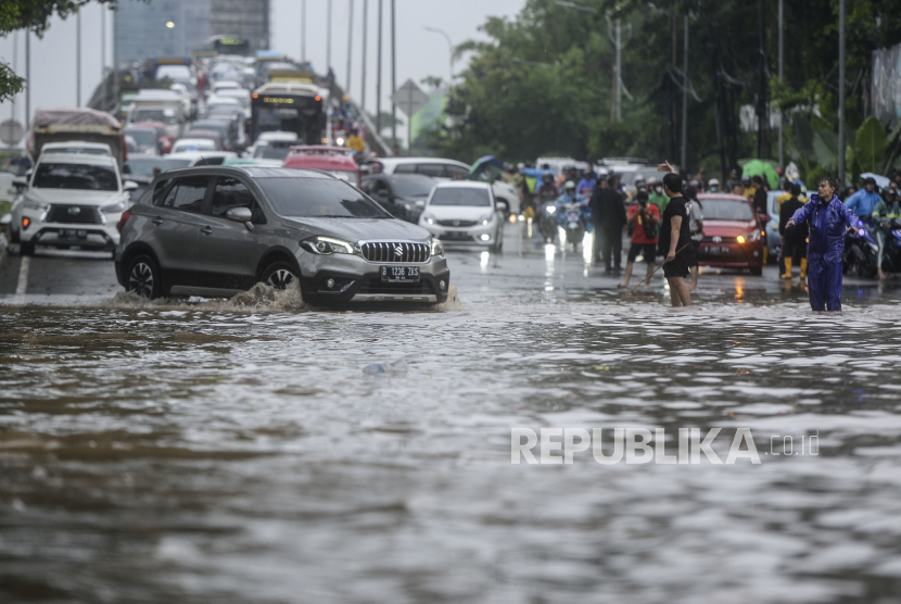 Mobil menerobos banjir di Jalan TB Simatupang, Jakarta, Kamis (6/10/2022). Banjir yang diakibatkan tingginya curah hujan membuat akses lalu lintas di jalan protokol tersebut lumpuh. Republika/Putra M. Akbar