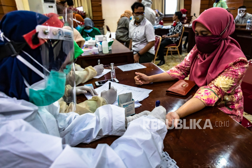 Petugas medis melakukan tes usap (swab) Covid-19 terhadap seorang pegawai ASN (ilustrasi)