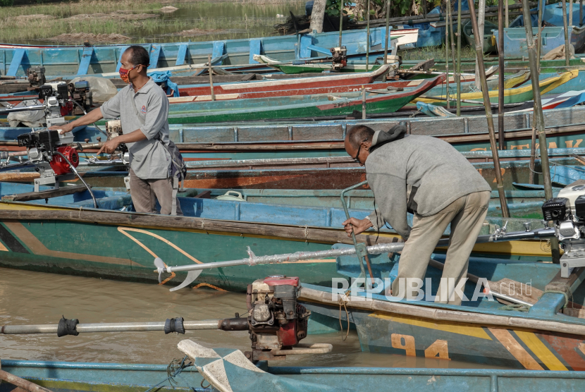 Dua orang nelayan mencoba perangkat konverter Bahan Bakar Minyak (BBM) ke Bahan Bakar Gas (BBG), untuk perahu mereka, yang dibagikan oleh Pemerintah, di Desa Cisuru, Gandrungmangu Cilacap, Jawa Tengah, Rabu (21/10/2020).  Sebanyak 2.000 nelayan di Cilacap, Jateng, menerima bantuan konverter kit BBM ke BBG dari pemerintah, sebagai upaya untuk optimalisas penyaluran BBG bersubsidi kepada masyarakat prasejahtera, dan membantu nelayan untuk mengurangi biaya melaut hingga 50 persen, jika dibanding menggunakan BBM. 