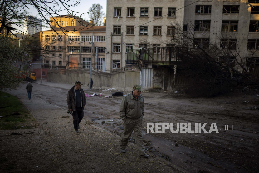 Orang-orang berjalan melewati lokasi ledakan di Kyiv, Ukraina, (ilustrasi). Presiden Ukraina Volodymyr Zelensky meluncurkan platform penggalangan dana global untuk membantu negaranya memenangkan perang melawan Rusia.