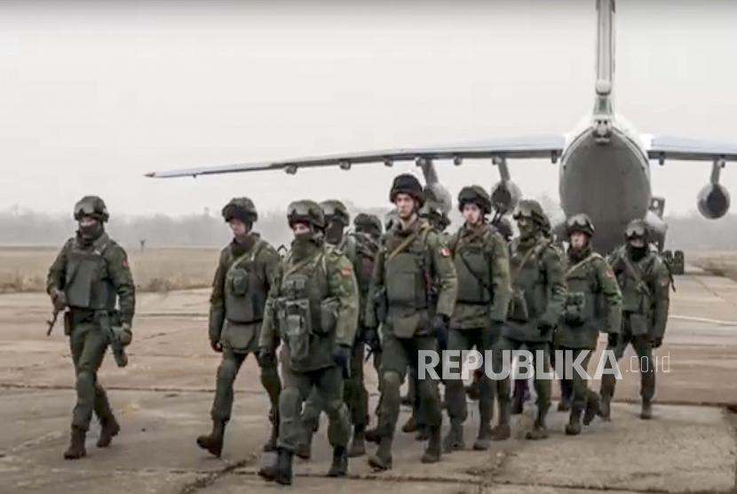 Dalam foto selebaran yang dirilis oleh Layanan Pers Kementerian Pertahanan Rusia, pasukan penjaga perdamaian Belarusia meninggalkan sebuah pesawat militer Rusia di sebuah lapangan terbang di Kazakhstan, Sabtu, 8 Januari 2022. 